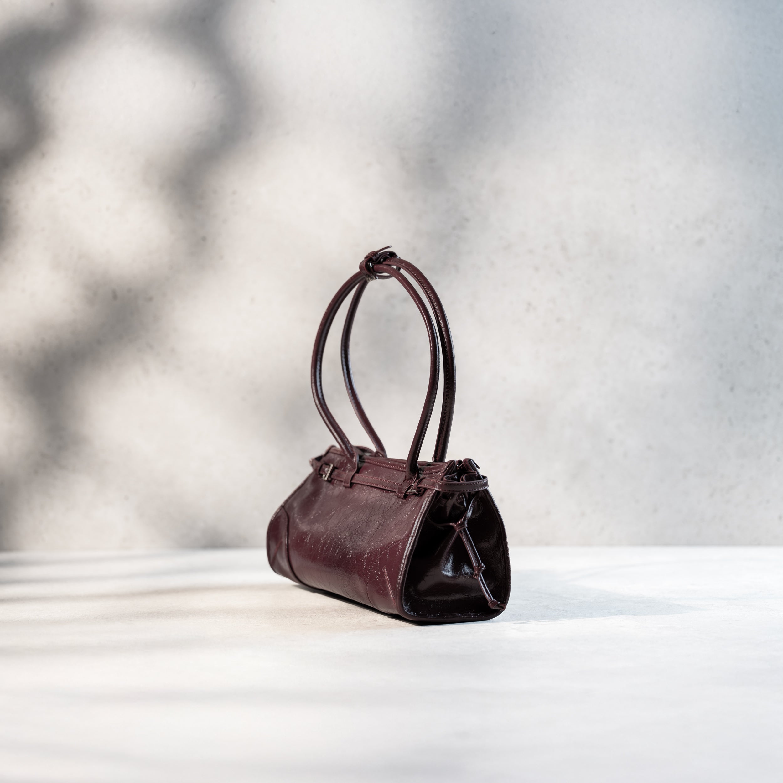 sac à main forme baguette pour femme en cuir verni bordeaux vintage de côté