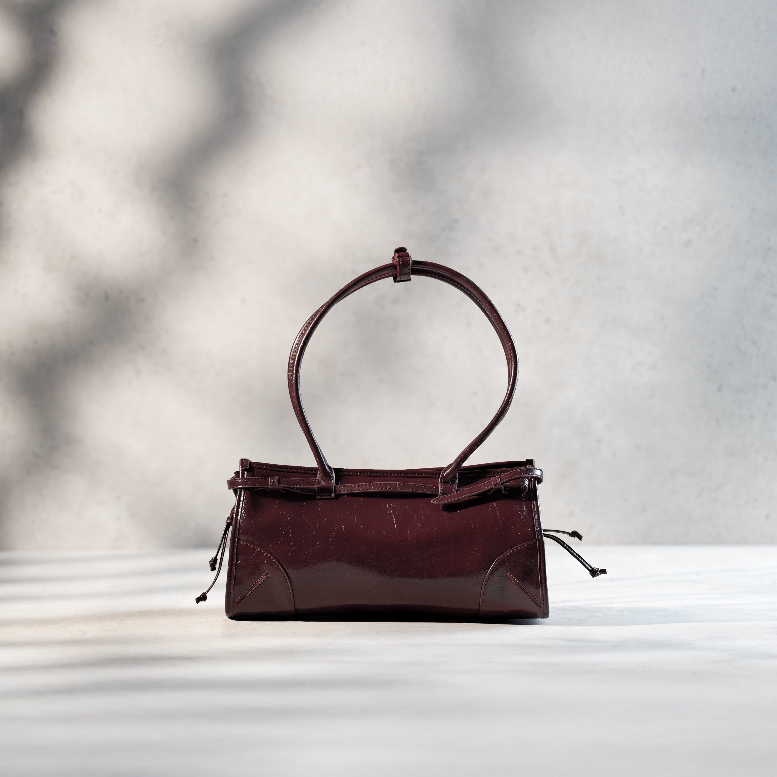 arrière d'un sac à main forme baguette pour femme en cuir verni bordeaux vintage