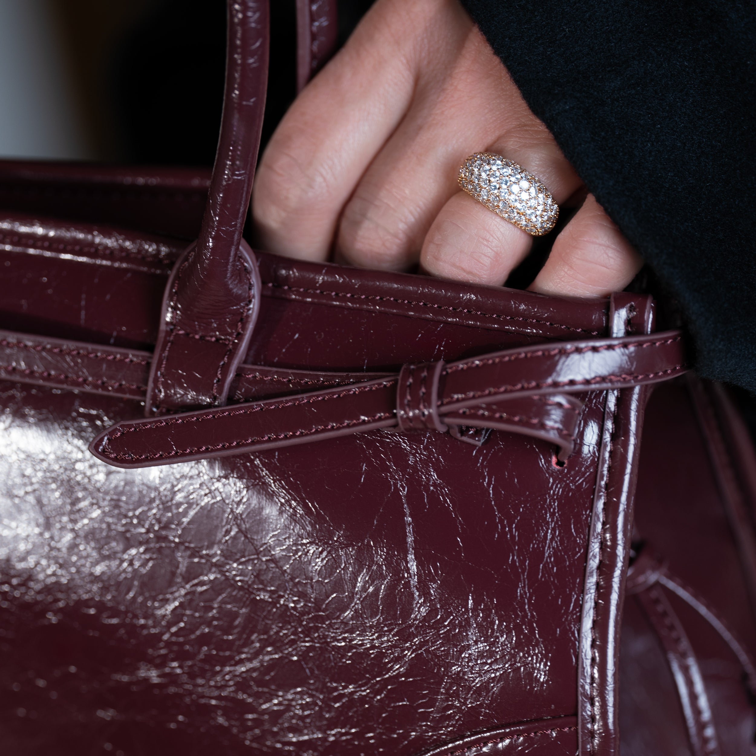 focus sur cuir d'un sac à main forme baguette femme en cuir verni bordeaux vintage avec bague en diamant