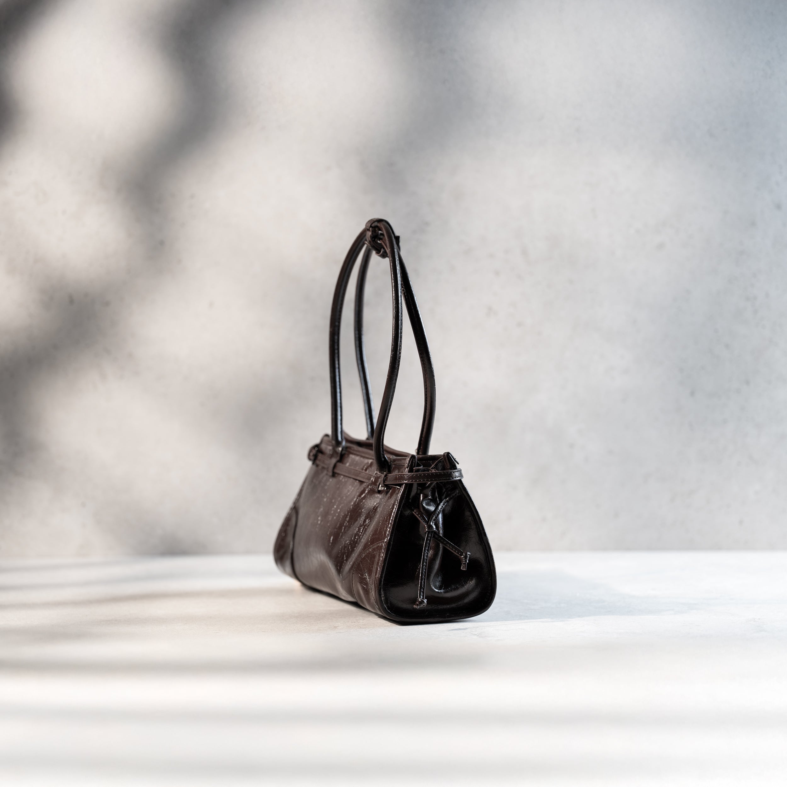 sac à main forme baguette femme en cuir verni marron vintage de côté