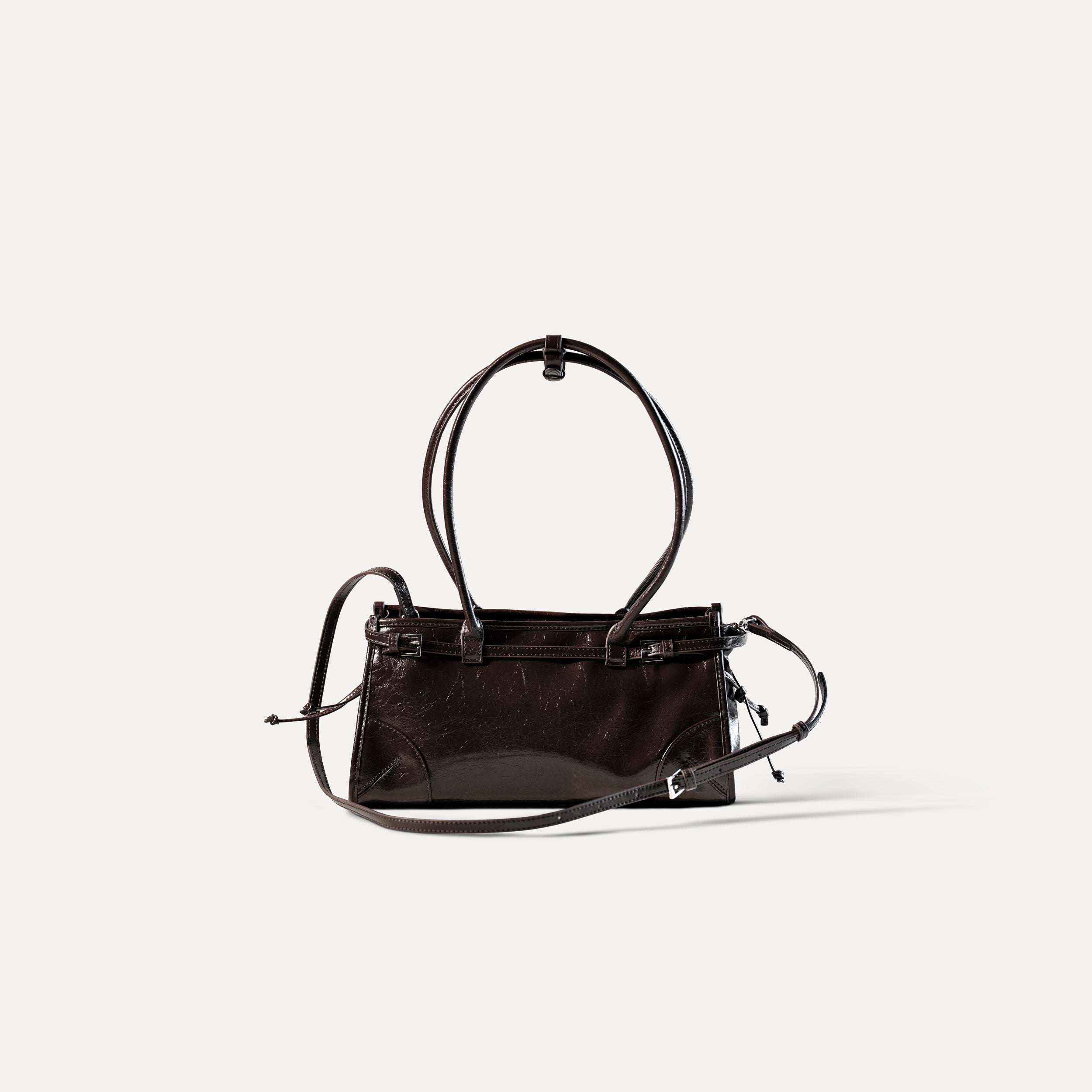 sac à main forme baguette femme en cuir verni marron vintage sur fond blanc