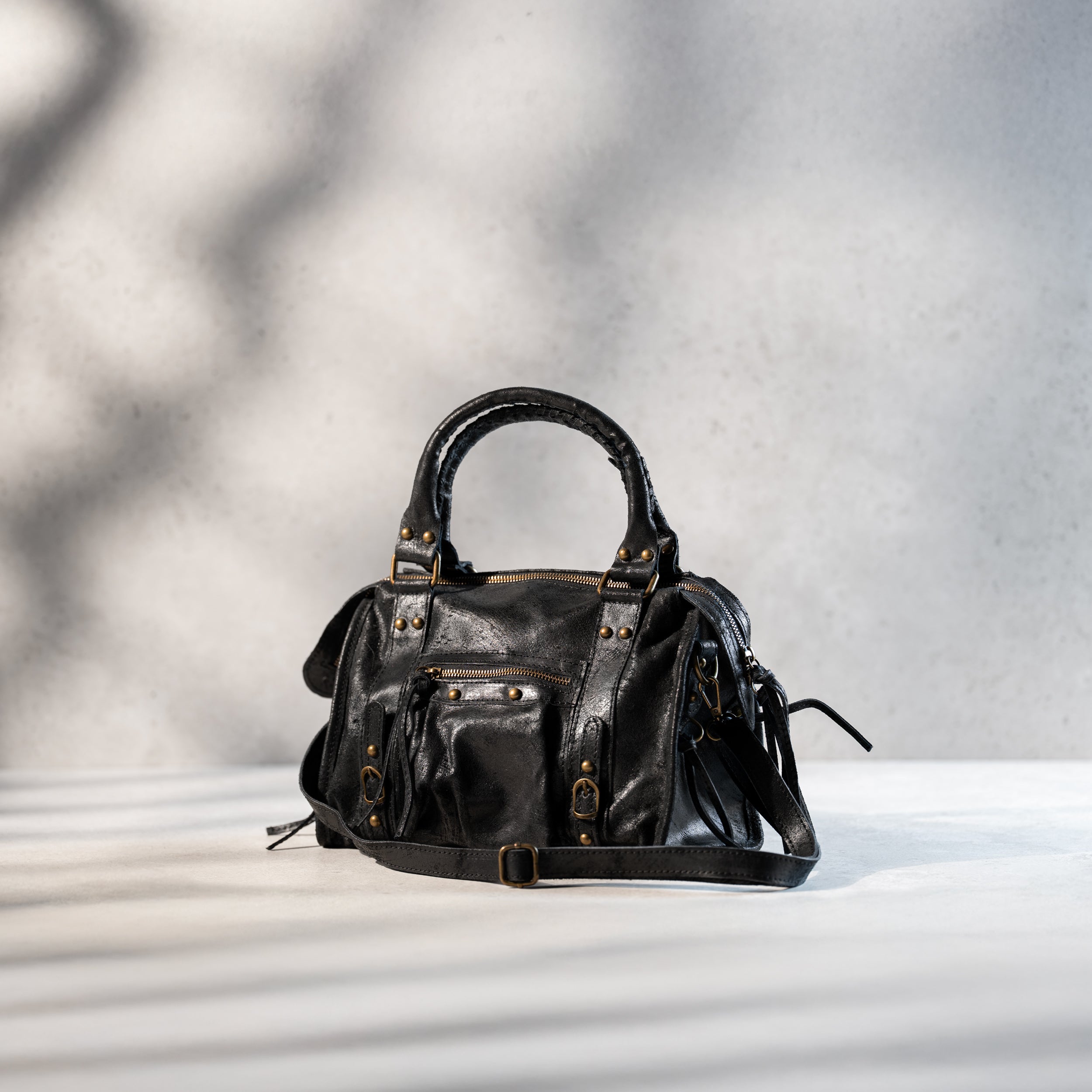 sac à main femme forme bowling vintage en cuir vieilli noir dans un cuir de veau souple avec bandoulière et bijouterie dorée