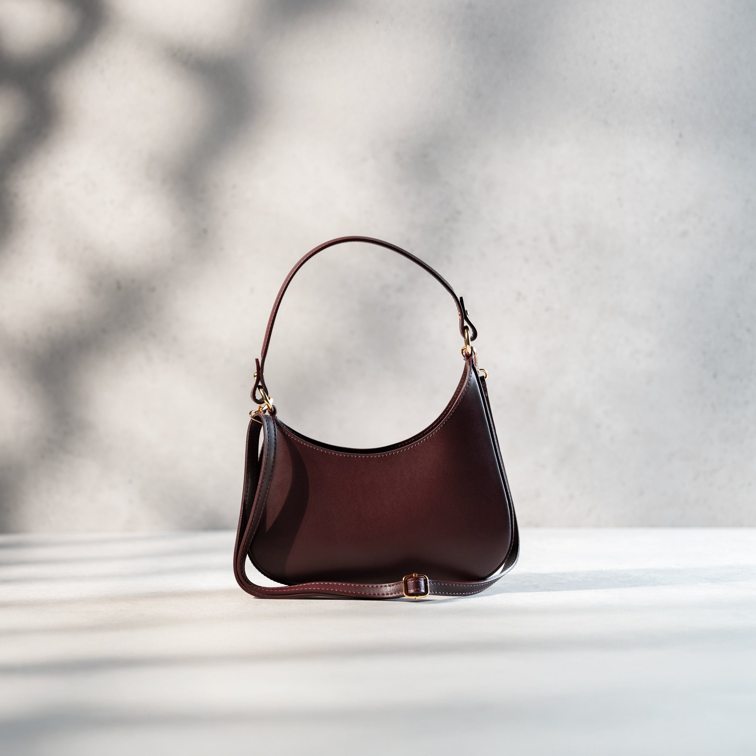 sac à main forme hobo demi lune asymétrique pour femme en cuir lisse bordeaux avec bandoulière