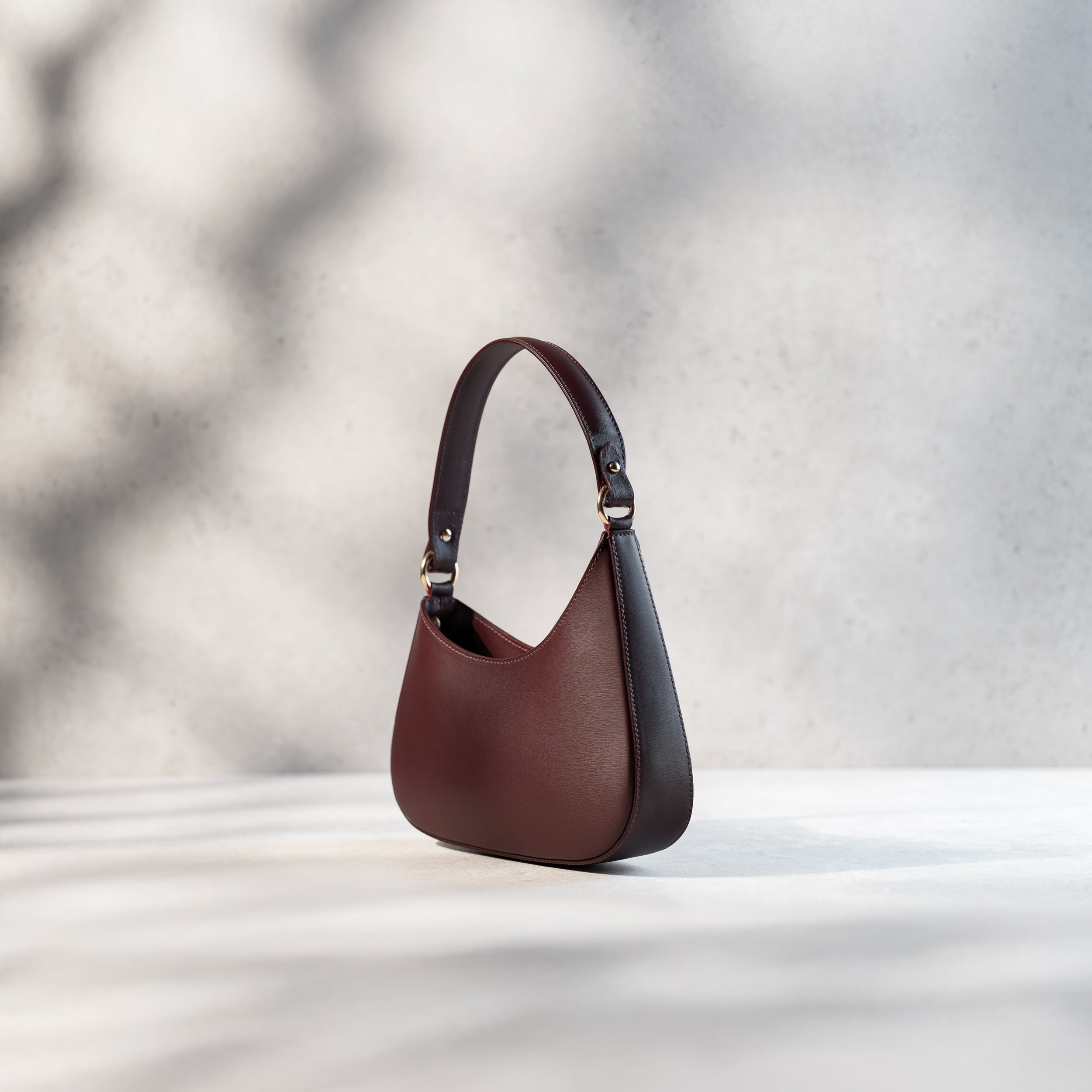 sac à main pour femme forme hobo demi lune asymétrique en cuir lisse bordeaux de côté