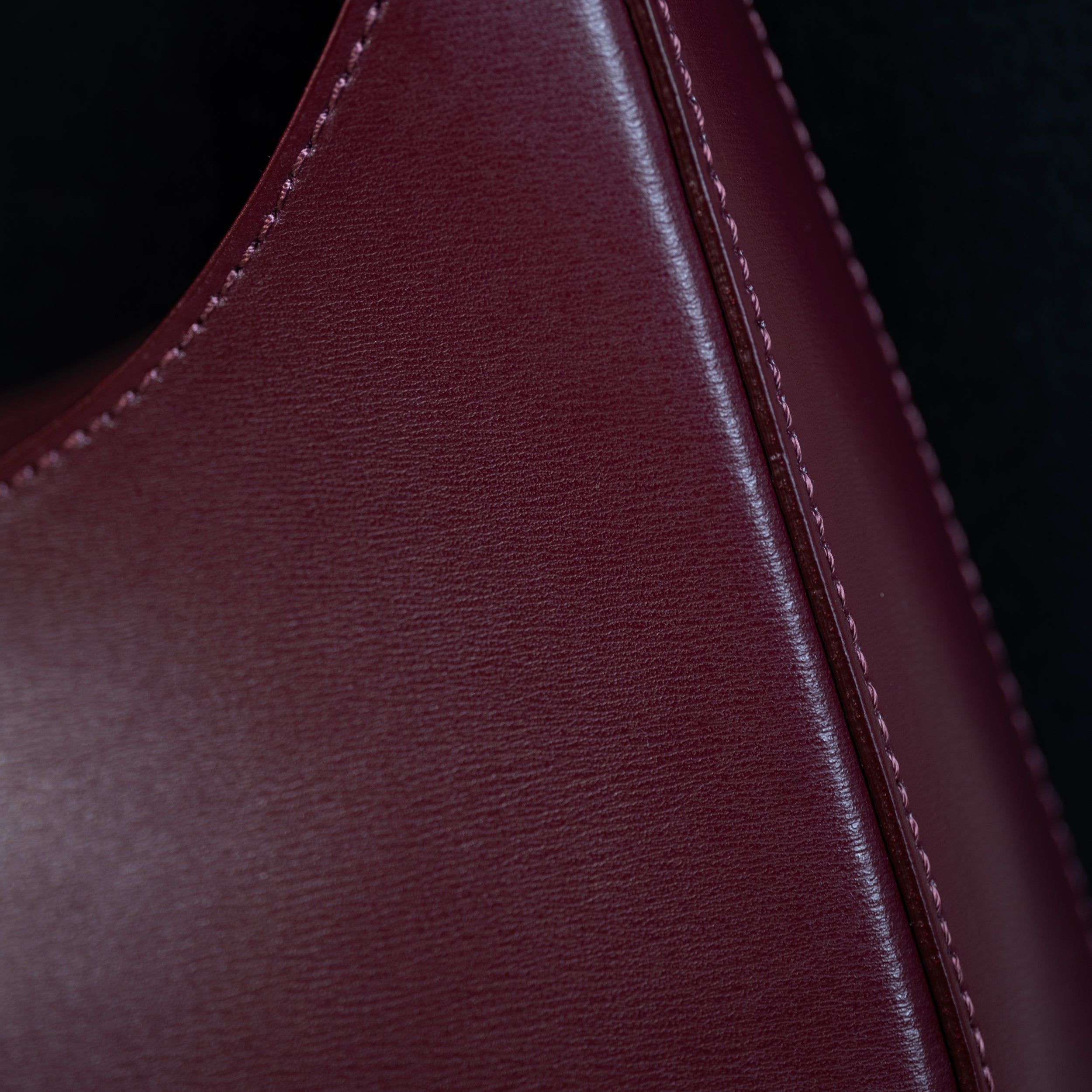 sac à main forme hobo demi lune asymétrique pour femme en cuir lisse bordeaux sur manteau noir