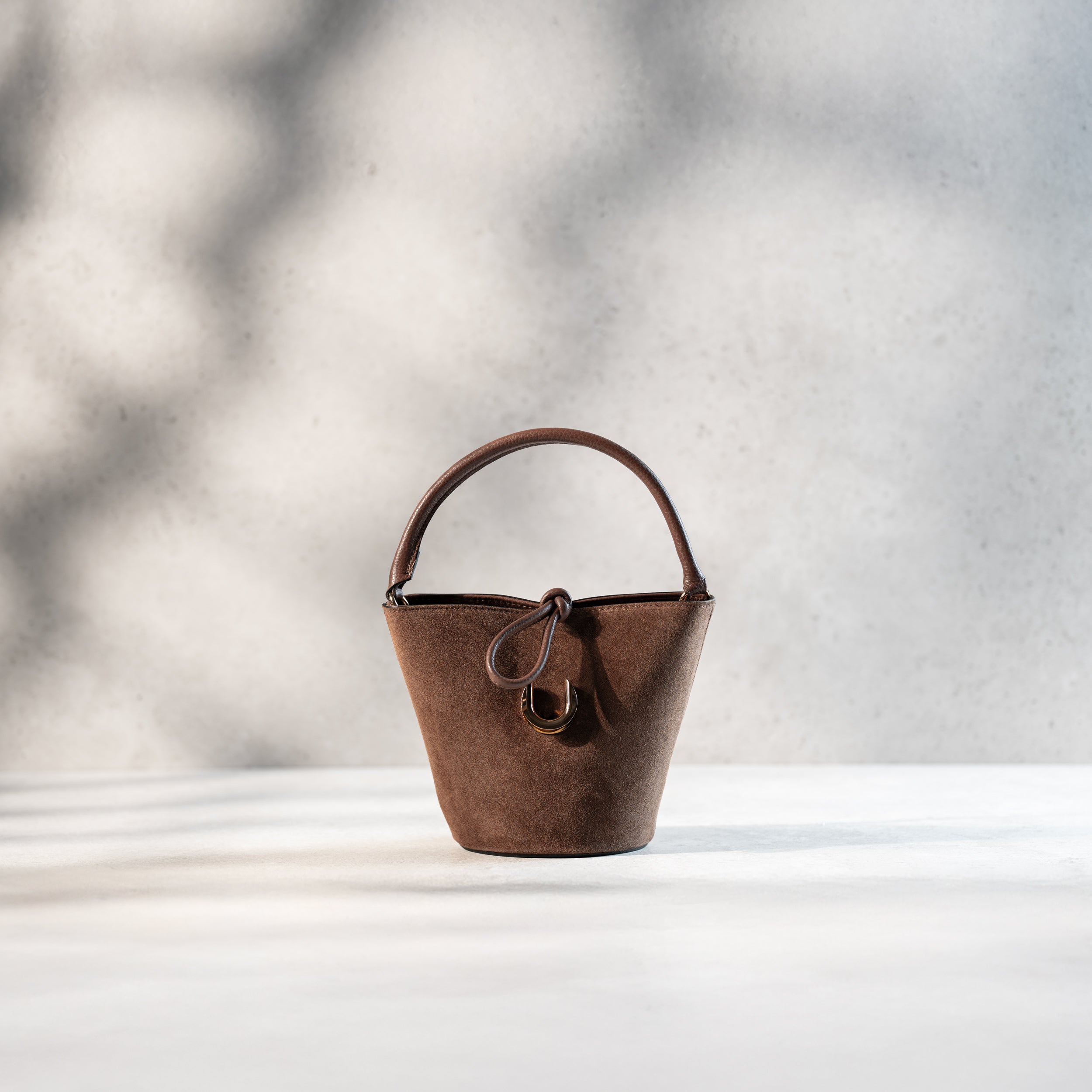 sac à main femme en cuir suédé ou daim brun en forme seau avec un fermoir doré original ouvert