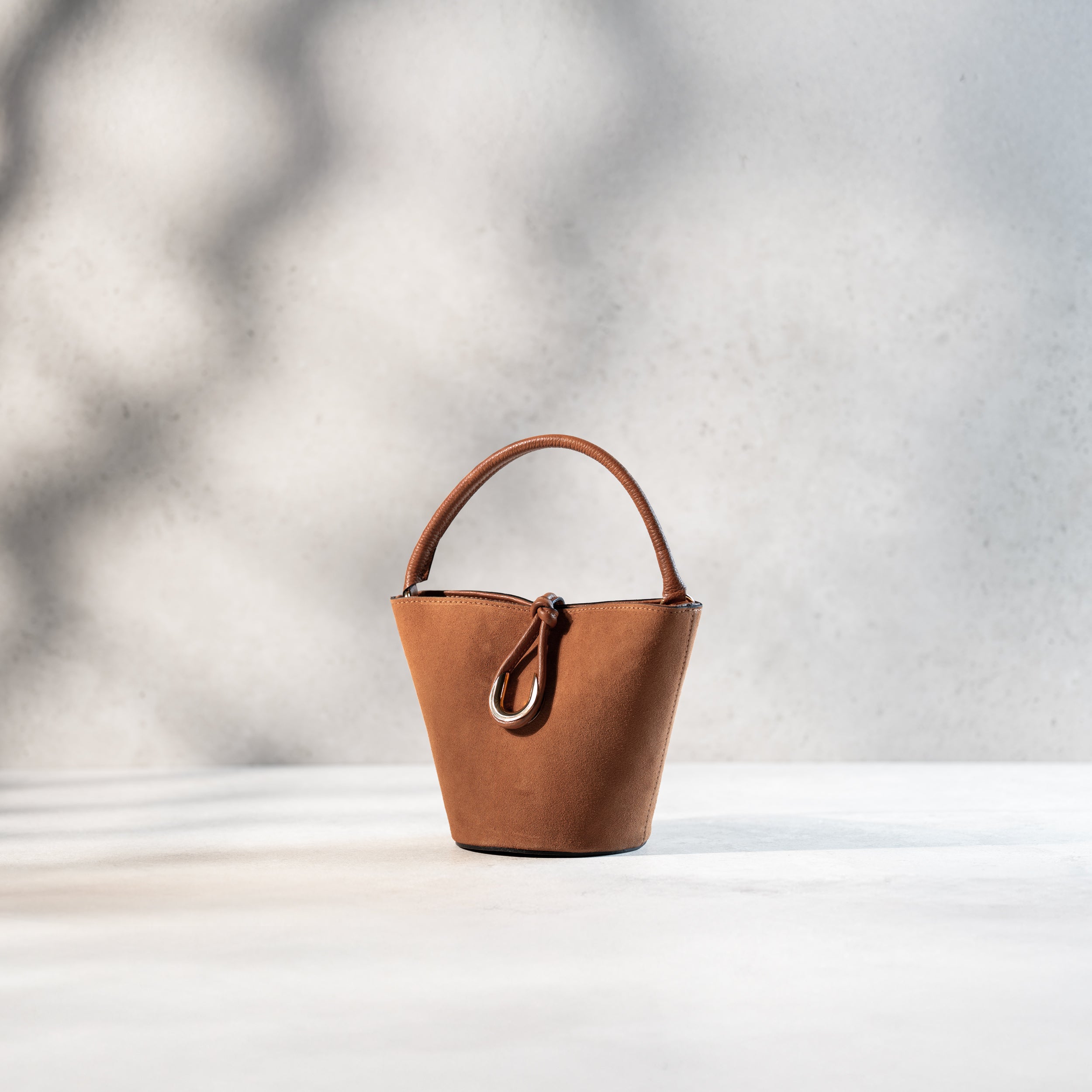 sac à main femme en cuir suédé ou daim camel en forme seau avec un fermoir doré original de côté