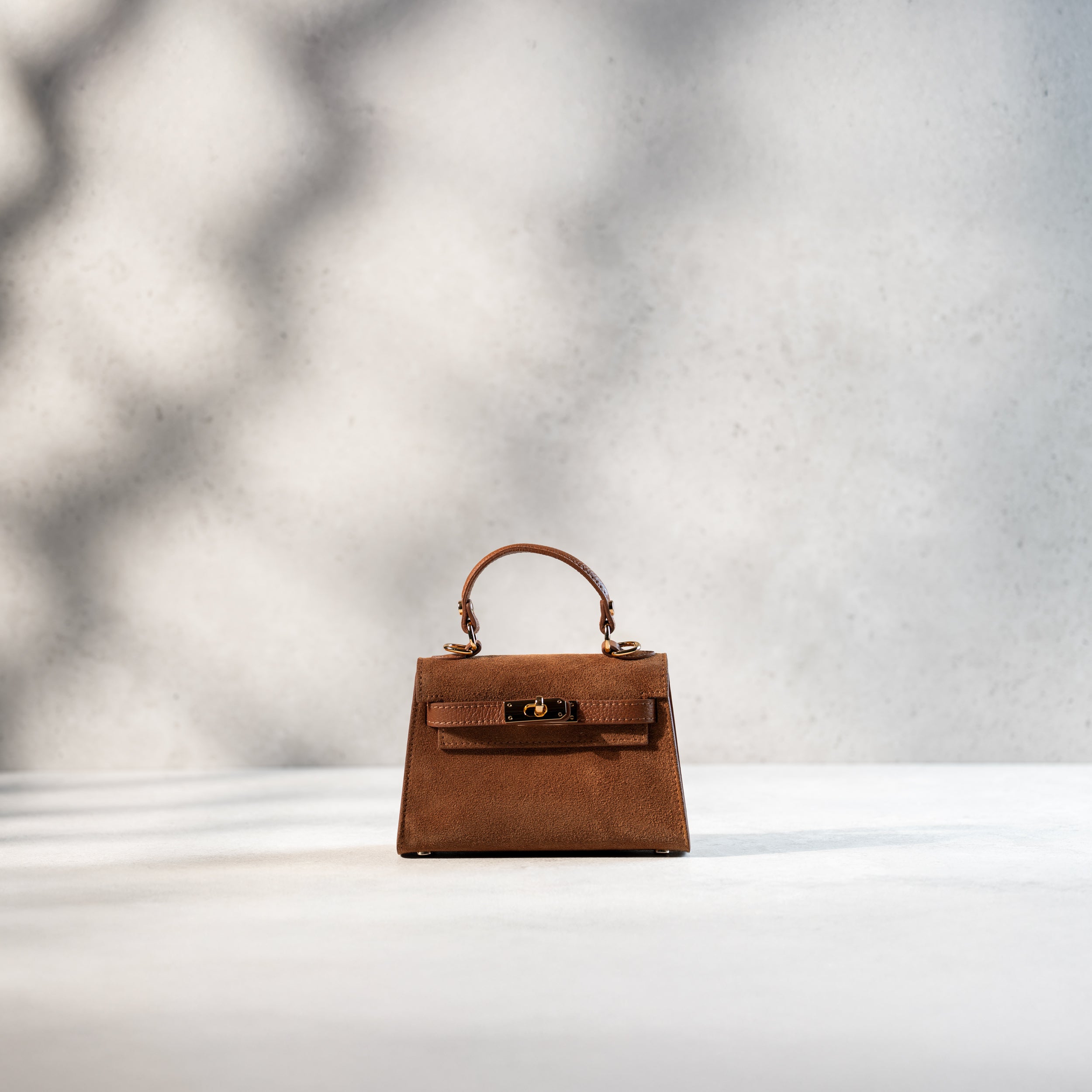 sac à main en daim format top handle avec fermoir tourniquet et bijouterie doré pour femme dans un cuir suédé camel 