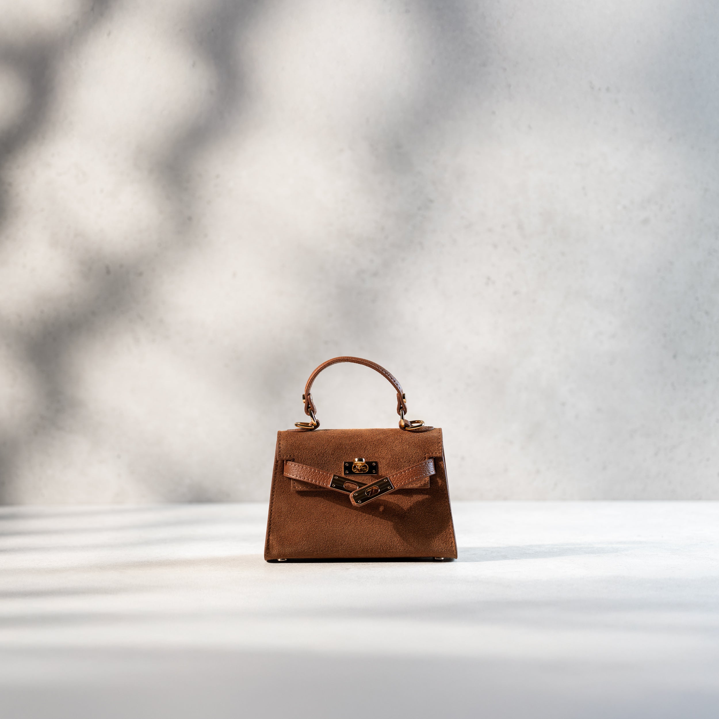 sac à main femme en daim top handle avec fermoir tourniquet ouvert et bijouterie doré dans un cuir suédé camel 